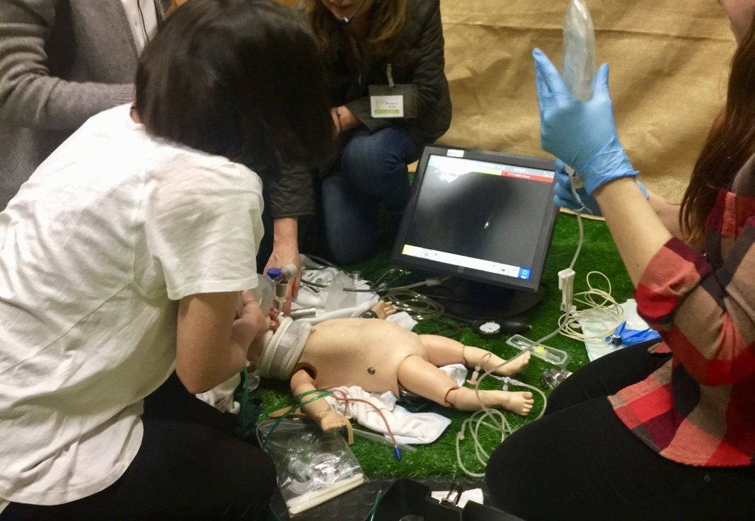 Sesión de simulación de reanimación neonatal con un equipo trabajando sobre el maniquí